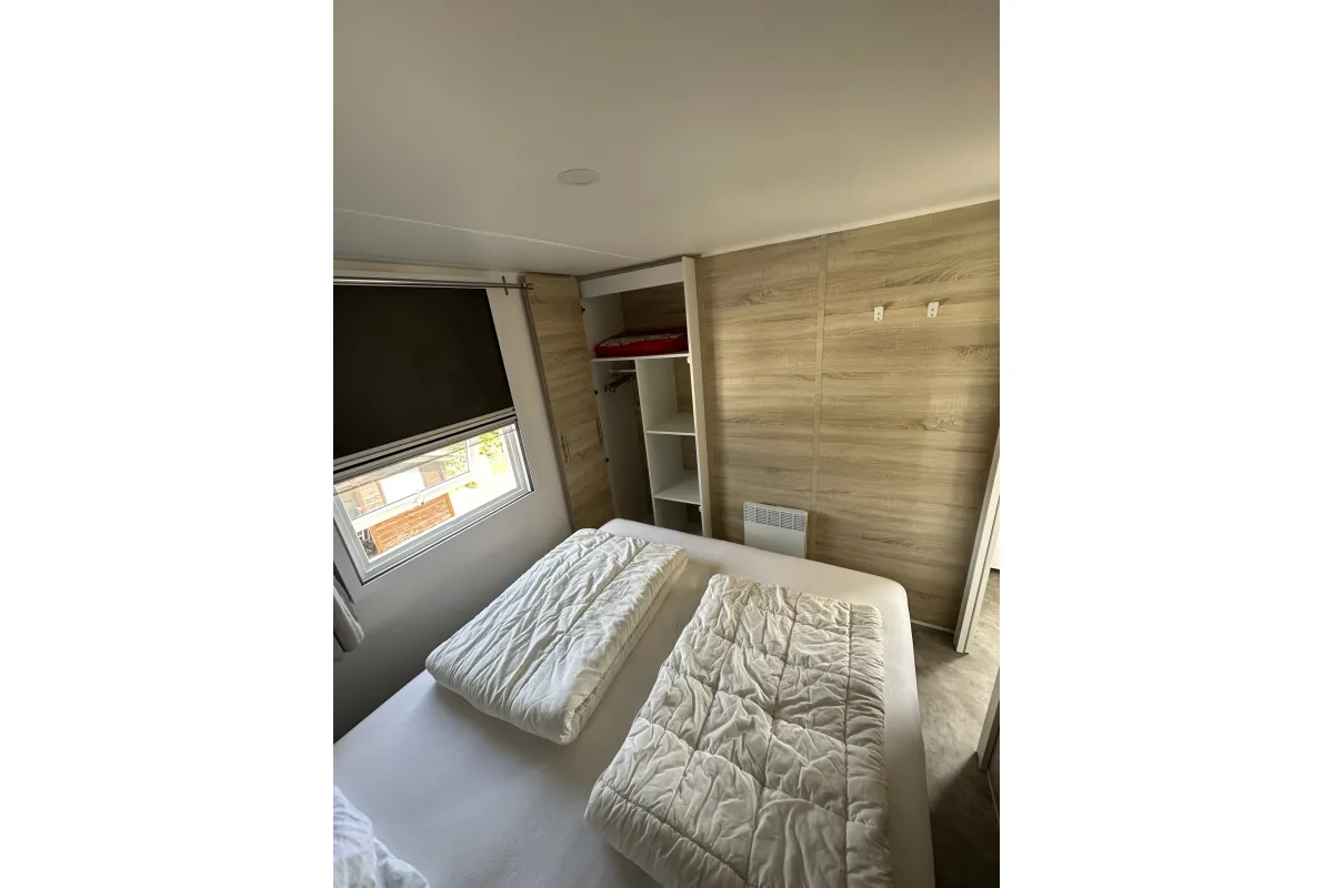 Grote slaapkamer met ruime boxspring en kledinkasten.
