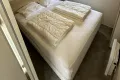 Grote slaapkamer met ruime boxspring en kledinkasten.