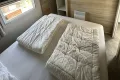 Grote slaapkamer met ruime boxspring en kledinkasten.